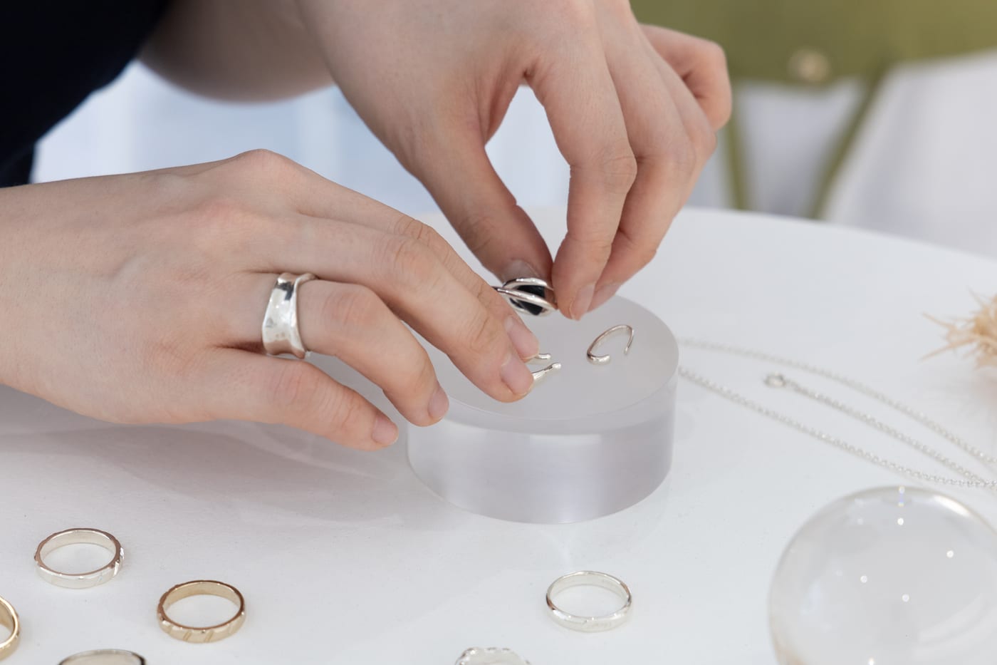 Hands assembling a ring on an acrylic block
